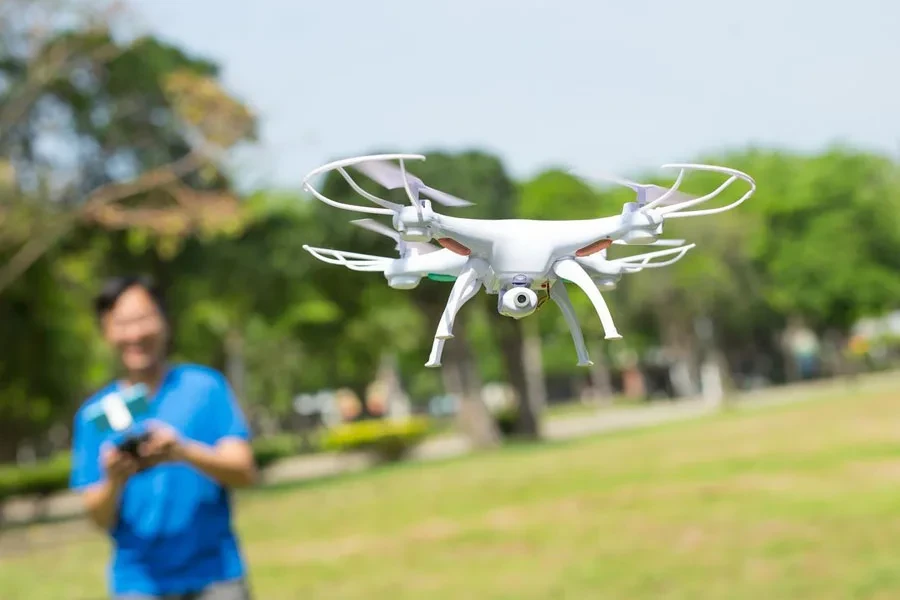 Mężczyzna bawi się dronem w parku