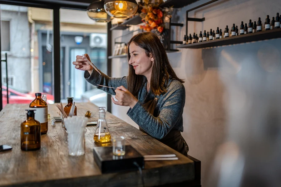 Een vrouw maakt parfums in haar winkel