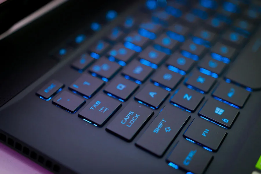 Keyboard Komputer Hitam dengan Cahaya Biru dalam Fotografi Close-Up