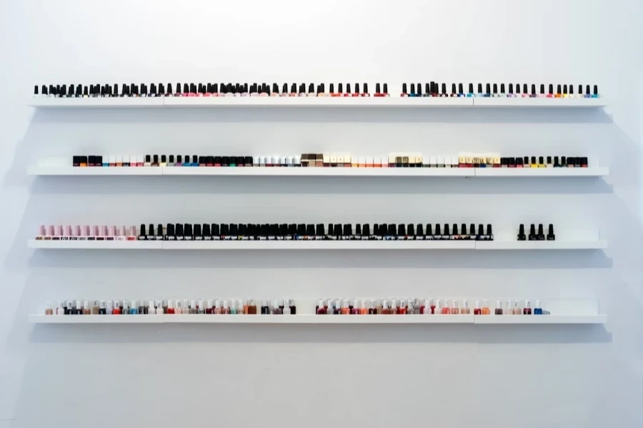 Collection of nail polishes lined up on shelves at home