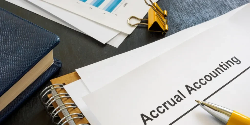 Document titled “Accrual Accounting” above notepad and pen