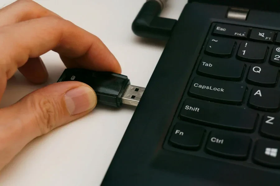 Les doigts insèrent une clé USB dans un ordinateur portable