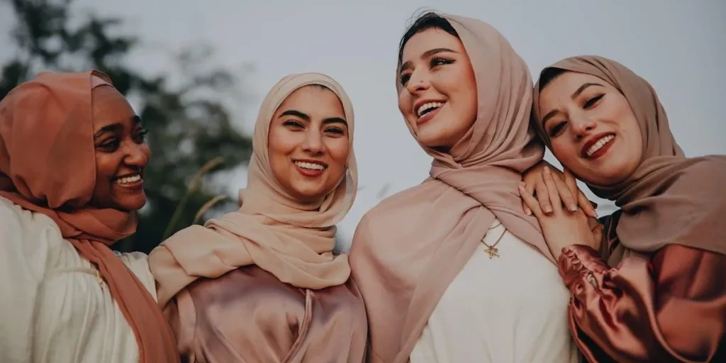 Empat wanita mengenakan gaya jilbab berbeda dan tertawa bersama