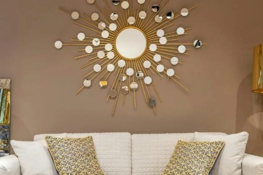 Gold sunburst wall mirror above couch