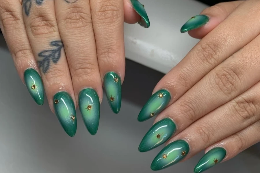 Green gel aura nails with small embellishments on top