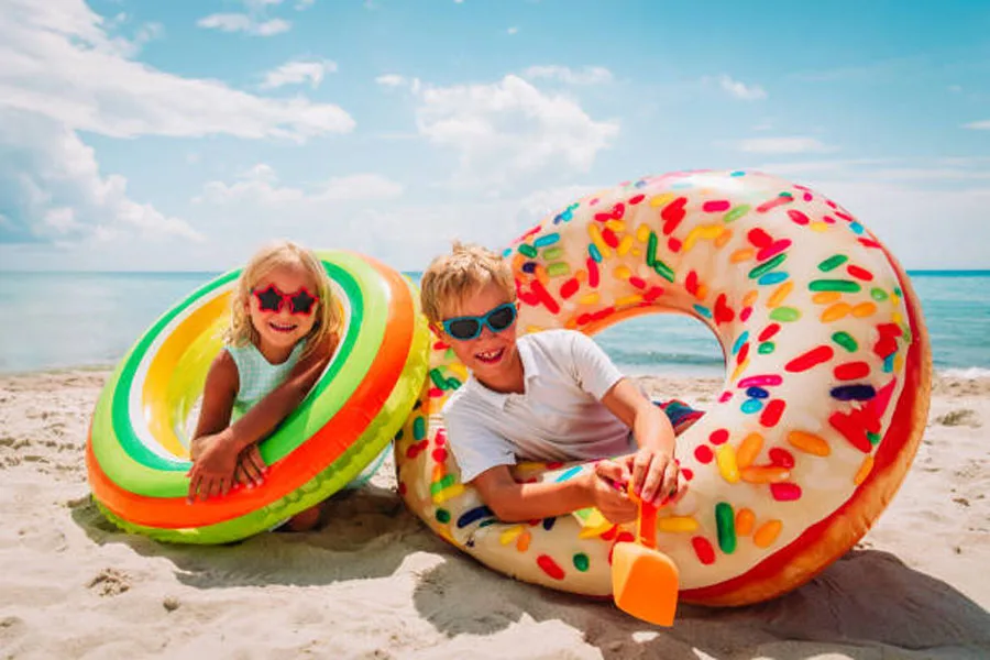 Happy Cute Boy and Girl Play with Floaties on Beach