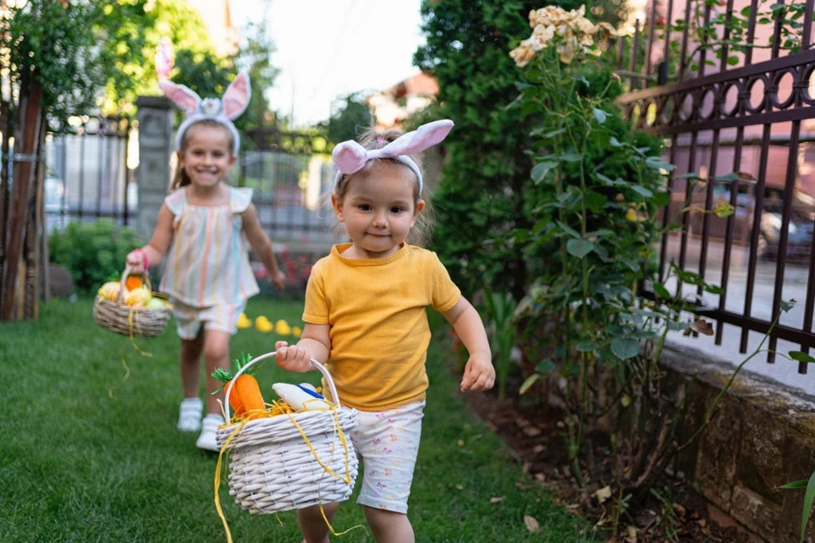 In the garden, Caucasian sisters together collecting Easter eggs during an Easter egg hunt