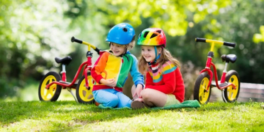 Niños andan en bicicleta de equilibrio en el parque