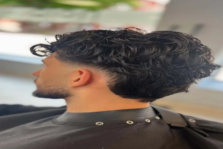 Man at hairdressers with new wavy burst fade haircut