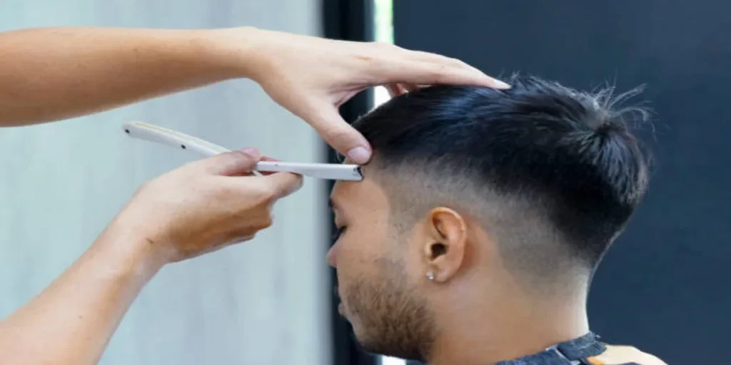 Homem recebe corte de cabelo estilo burst fade feito por cabeleireiro profissional