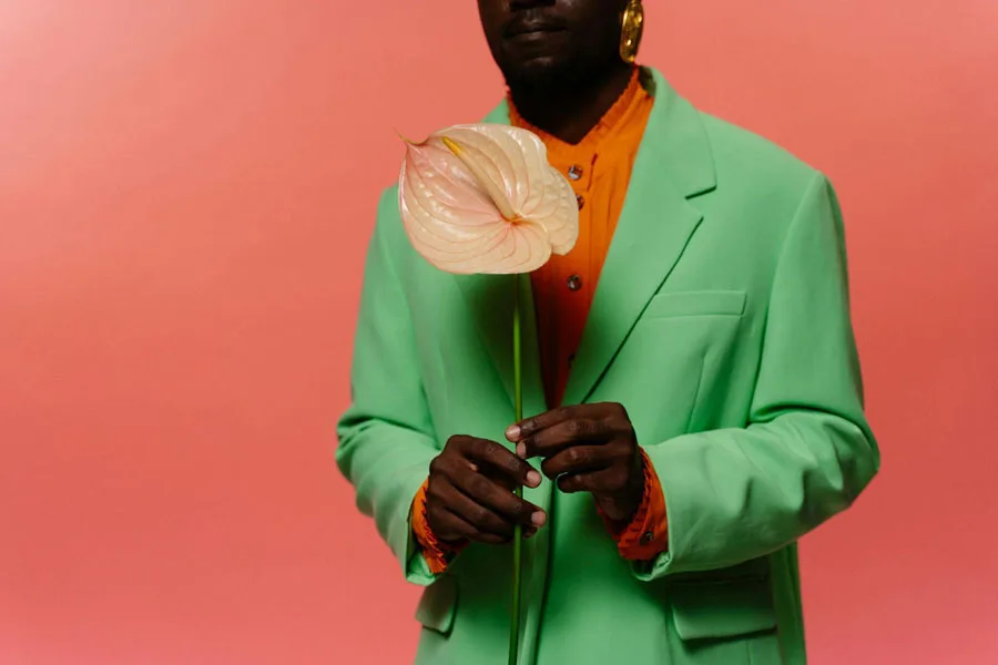 Man in Colorful Suit Holding a Flower