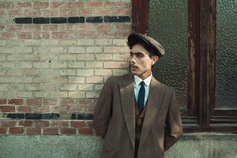 Man in Suit Leaning on Brick Wall