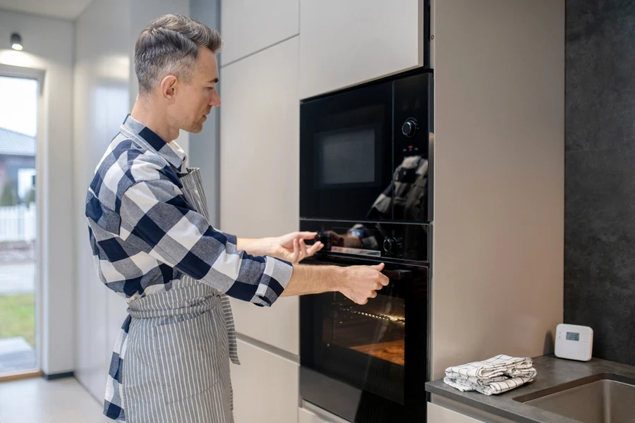 Man using an oven with a simple design