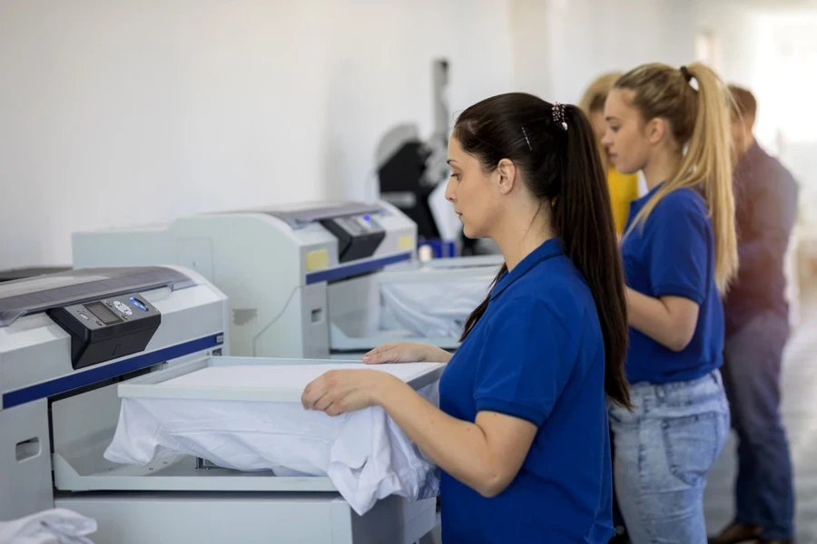 People printing designs on white T-shirts