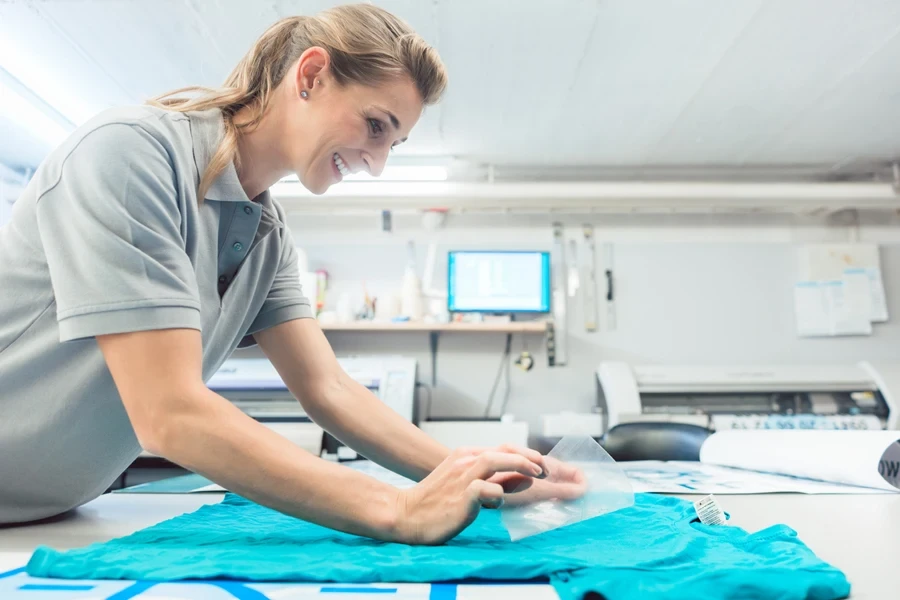 Smiling woman removing a PET film from a shirt