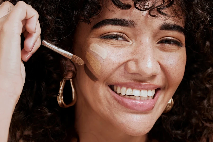 Smiling woman trying different foundation colors