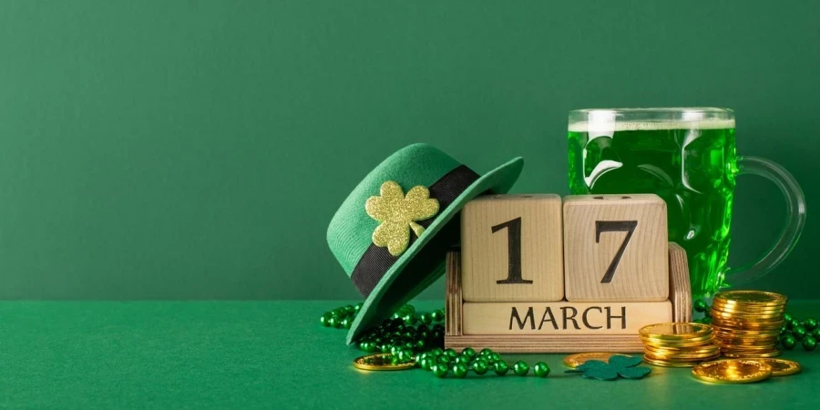 Susunan pandangan sisi St. Paddy's Day Blok tarikh, bir berbuih, khazanah syiling, periuk leprechaun, topi dengan tanda shamrock, manik pada em