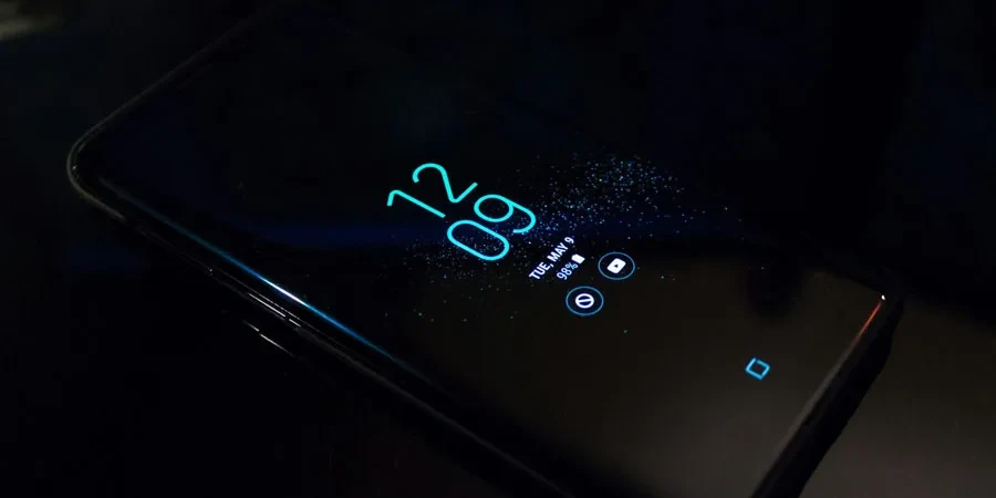 Teléfono inteligente Android negro encendido que muestra el reloj a las 12:09