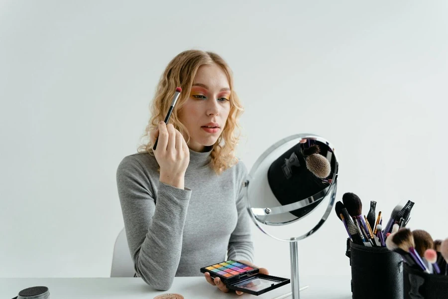 Mujer sosteniendo un pincel de maquillaje de ojos