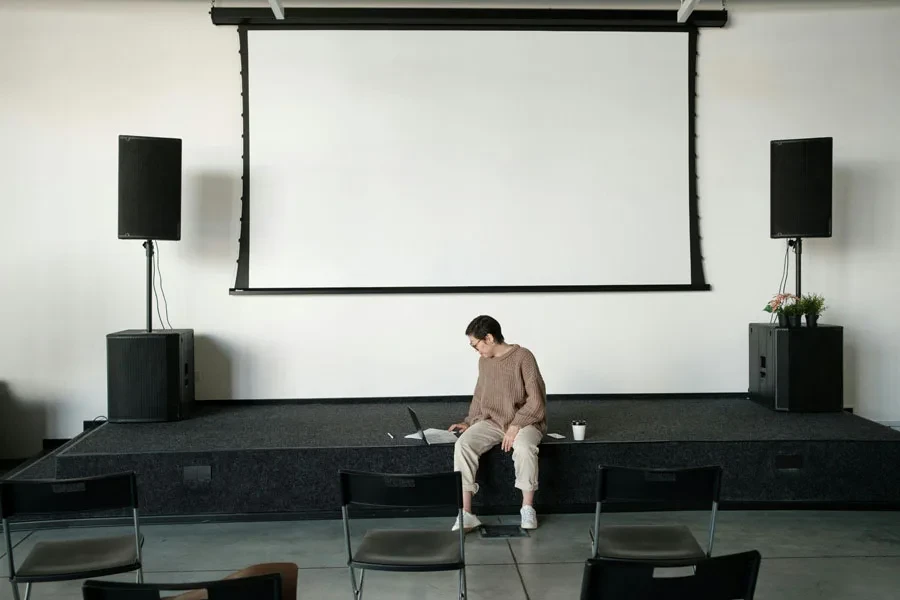 Femme assise par terre dans une salle de conférence et travaillant