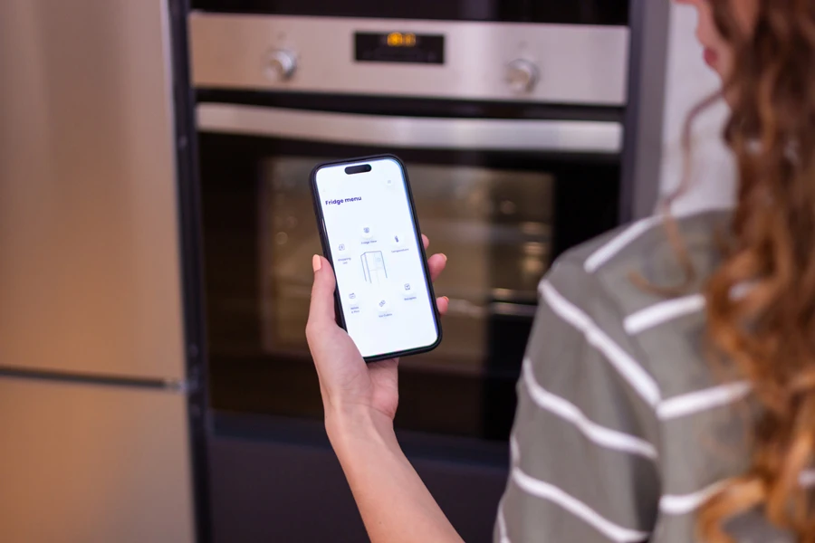 Woman controlling her AI oven with her phone