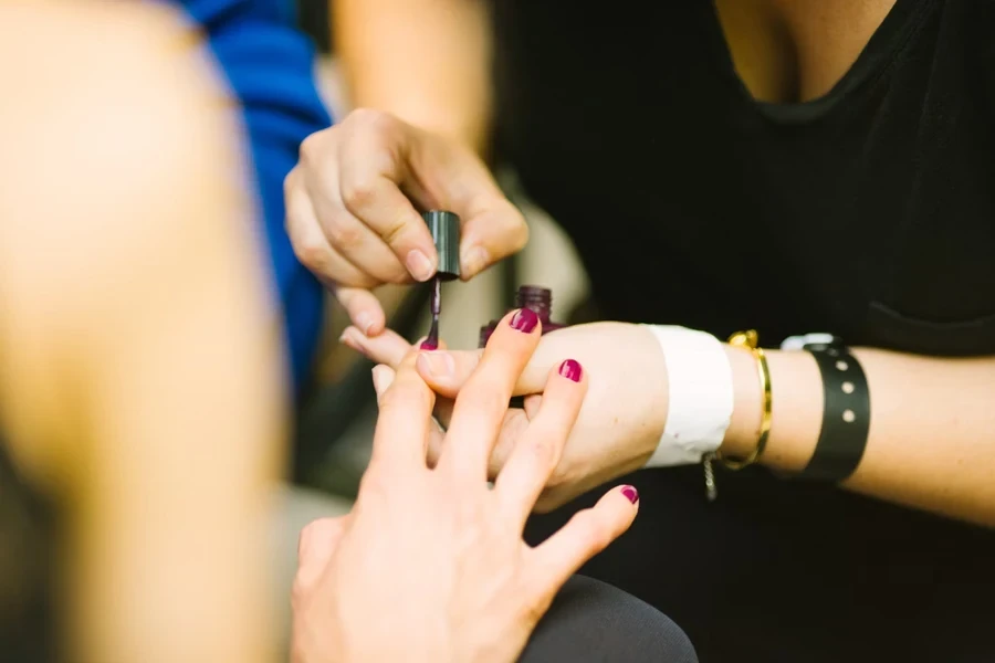 Woman painting nails in nail salon after Russian manicure