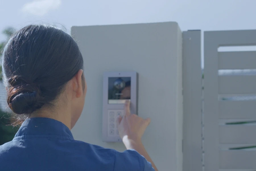 Woman pressing a smart doorbell