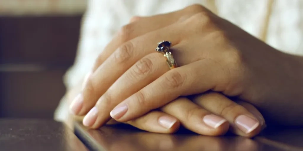 Woman with classic Russian manicure wearing wedding ring