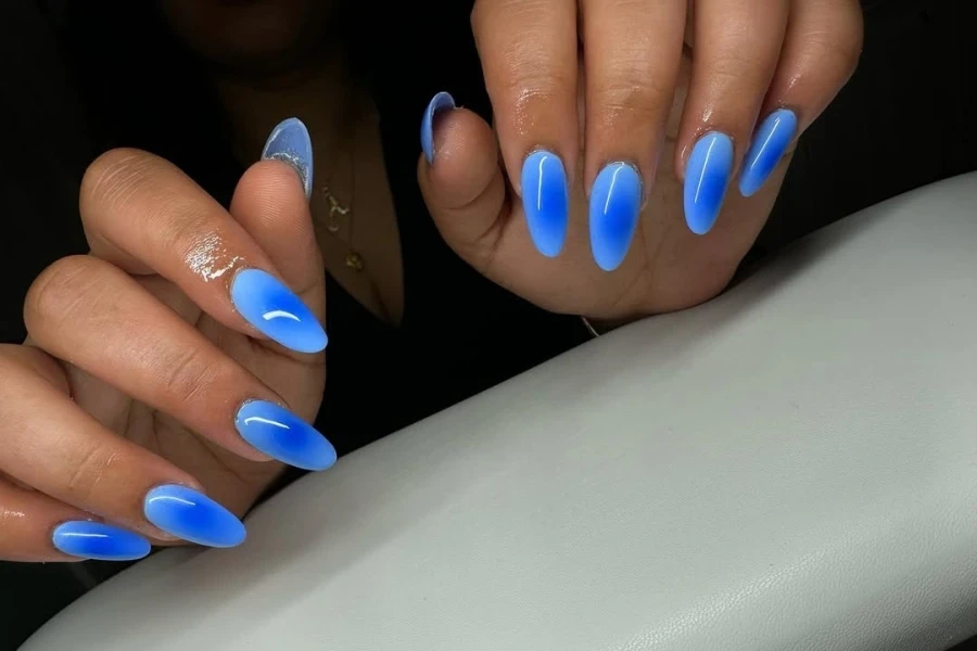 Woman with glossy top coat aura nails in salon