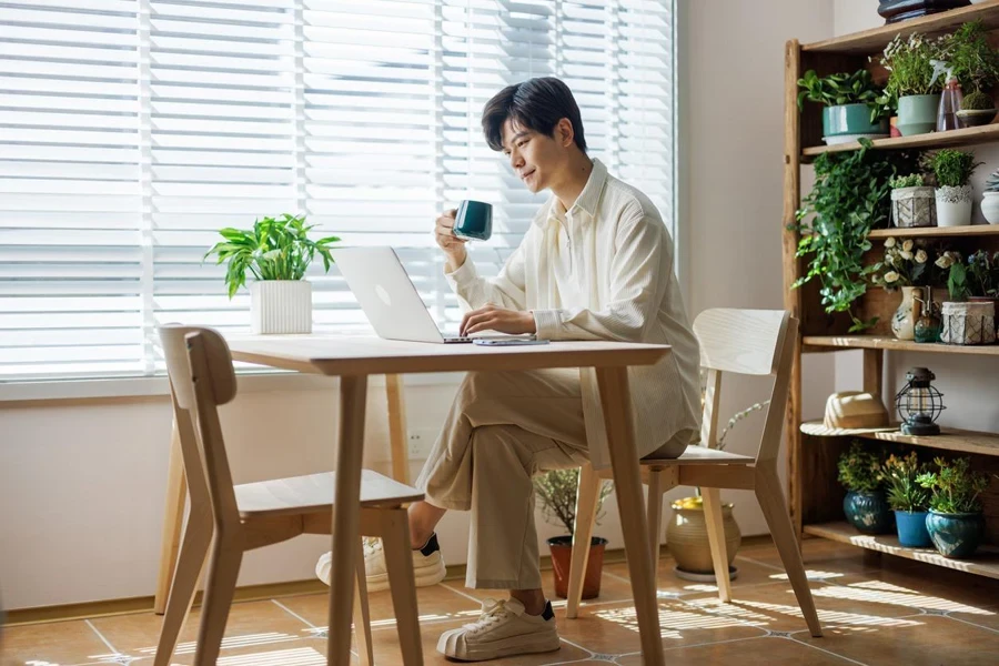 Junge Männer trinken Kaffee und arbeiten an Laptops