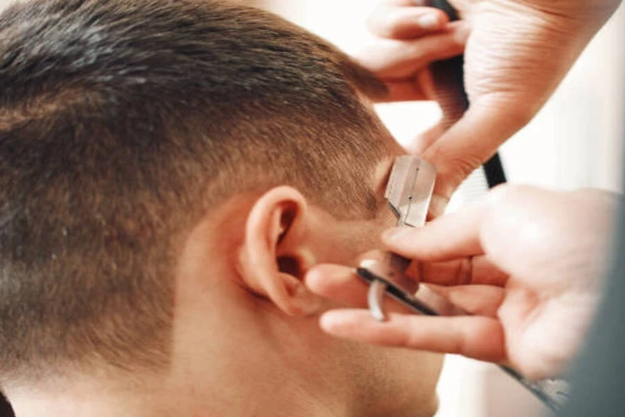 Pria muda potong rambut di tukang cukur dengan rambut yang mulai memudar