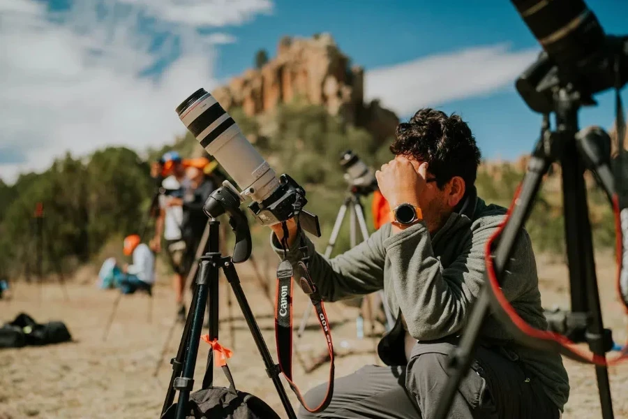 Un fotografo con le macchine fotografiche montate su treppiedi