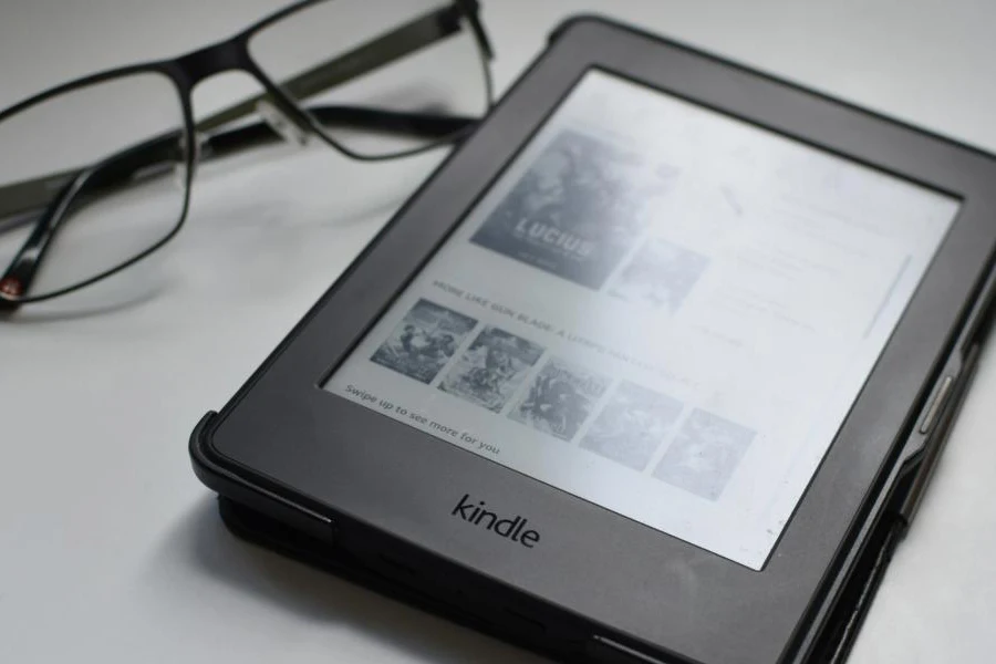 Kindle auf einem Schreibtisch neben einer Brille