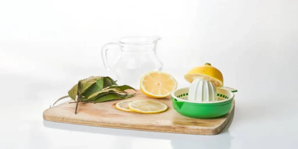 Manual lemon squeezer on wooden chopping board in kitchen