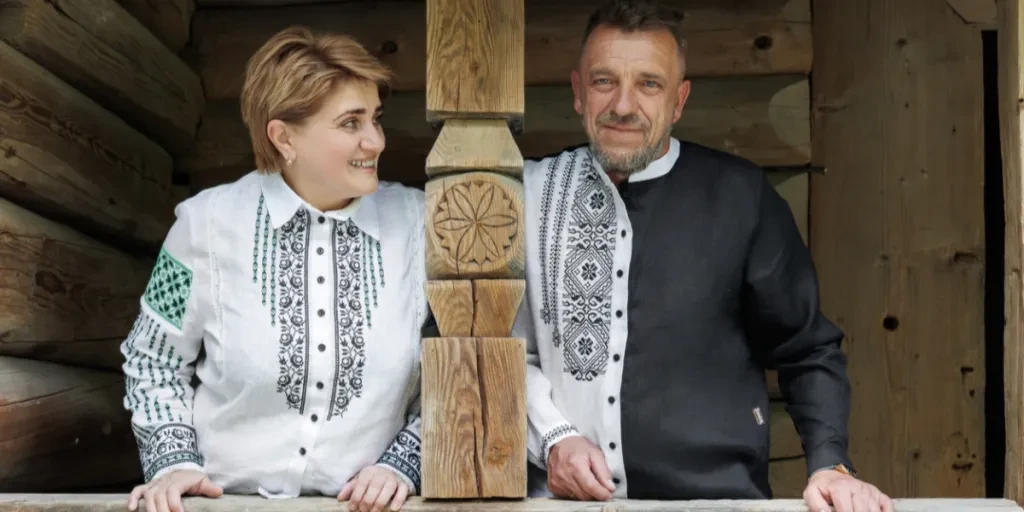 A man and woman wearing embroidered shirts
