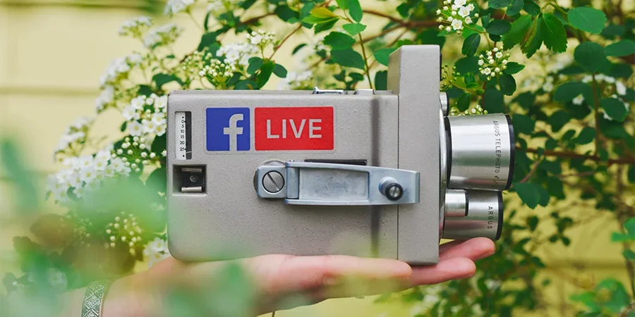 Camera with a Facebook Live logo surrounder by flowers