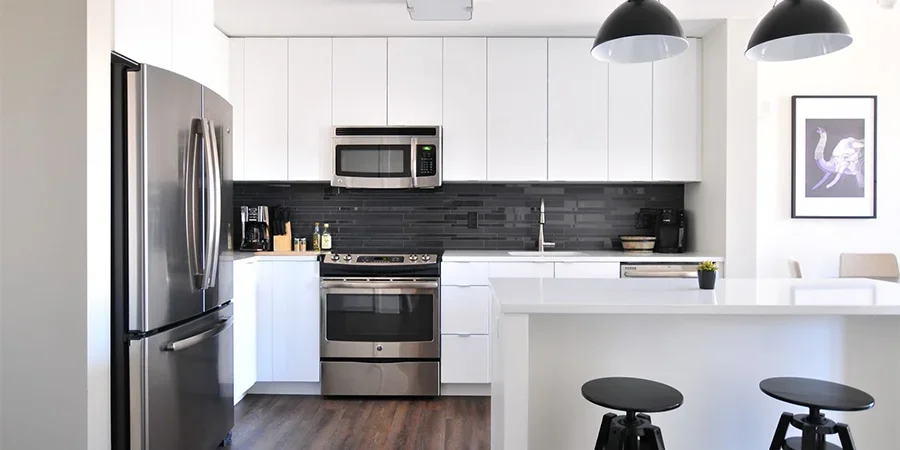 Modern white kitchen with black mosaic tiled backsplash
