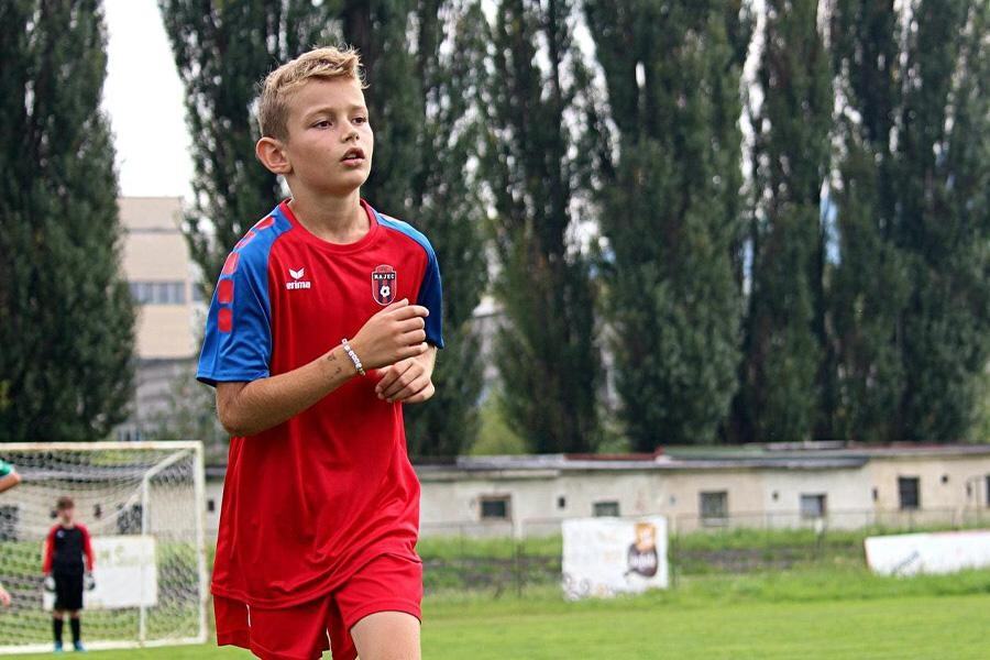 A boy wearing a red color jersey