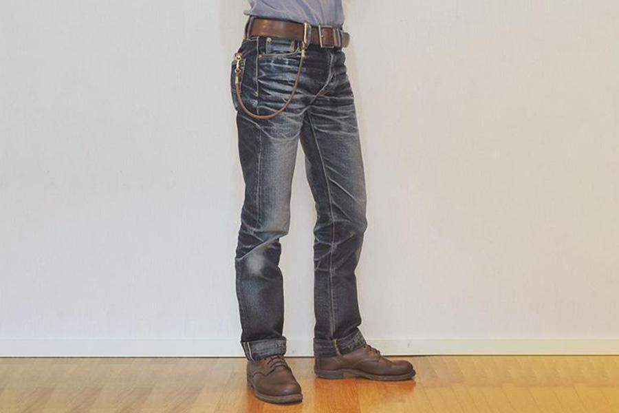 A man in faded denim trousers