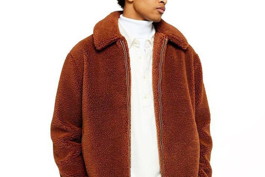 A man wearing an oxide orange wool sweater