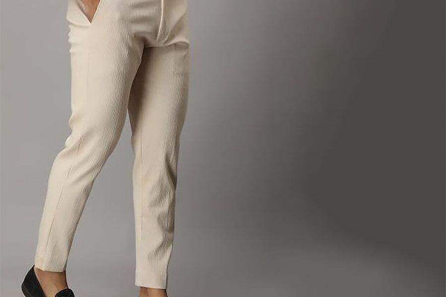 Мужчина в кремовых зауженных брюках.