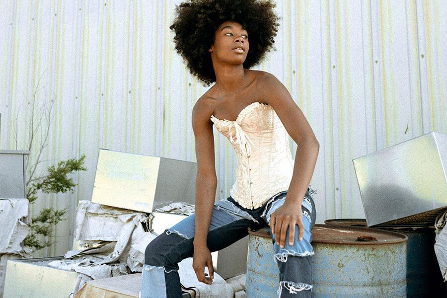 Lady wearing a corset top and patchwork denim pants