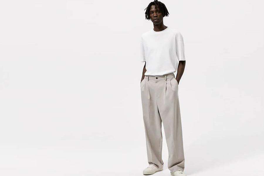 Модель с дредами в серых широких брюках