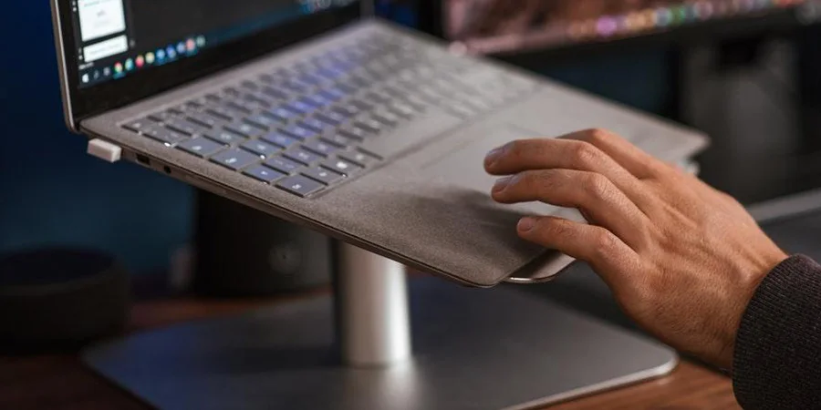 Person using a laptop placed on a laptop stand