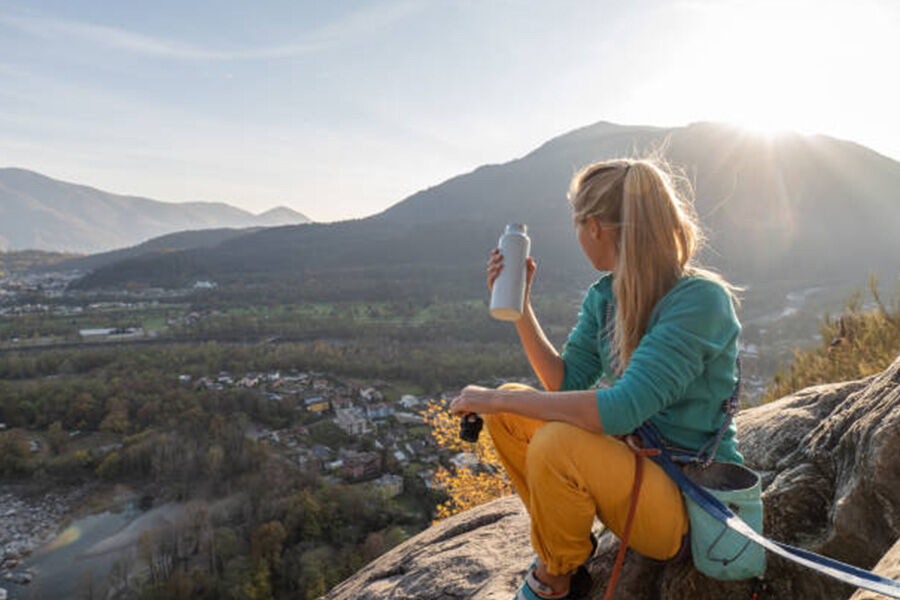 Mujer sentada en un mirador con una botella de agua blanca