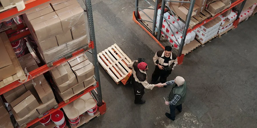 Workers between shelves in a warehouse