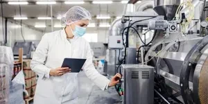 Food producer inspecting food processing equipment