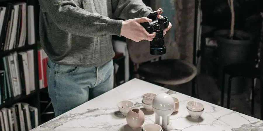 Man creating product photos with camera and artificial light