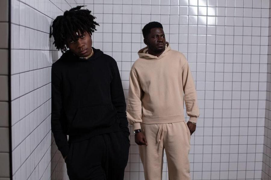 Hombres posando en conjuntos negros y crema