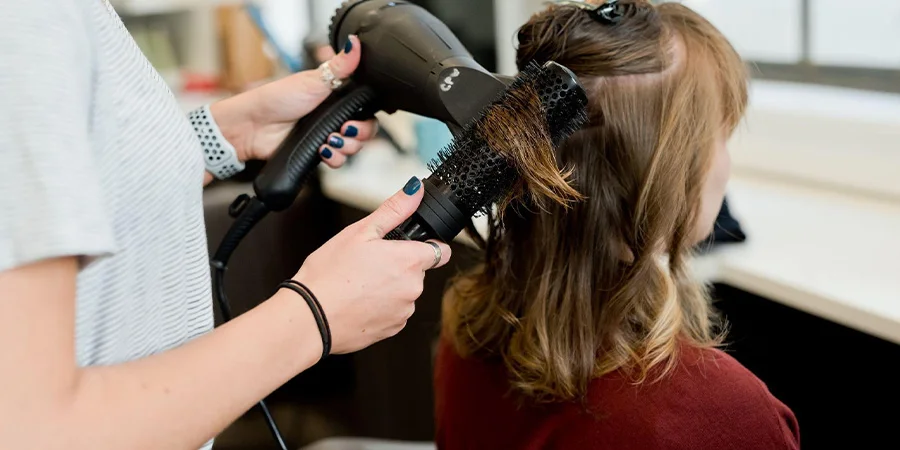 Woman getting hair blown with a hair dryer